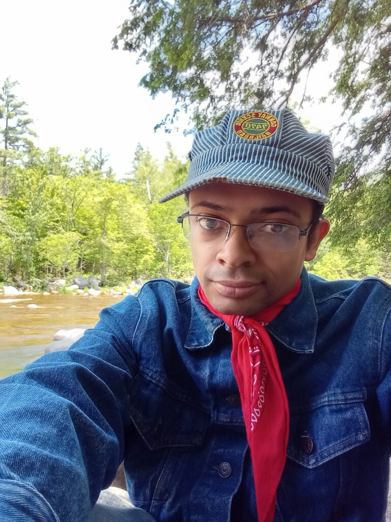 Corey Burrell sitting in front of a river.